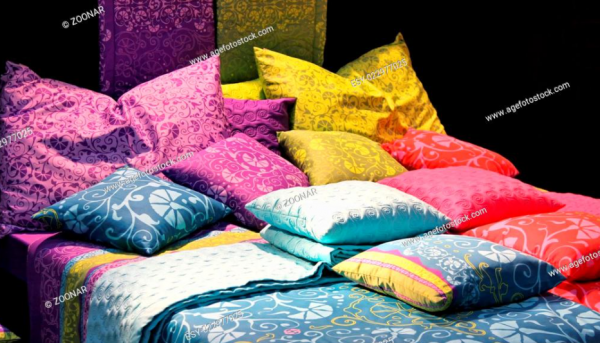 Tumpukan Bantal pada Ranjang dengan Warna Kontras